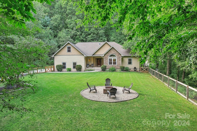 view of front of house with an outdoor fire pit and a front lawn