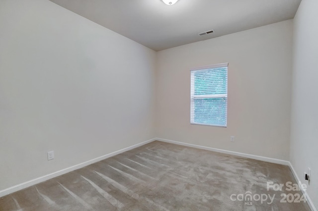 unfurnished room featuring light carpet