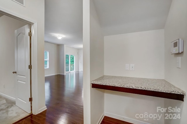 corridor with dark hardwood / wood-style flooring