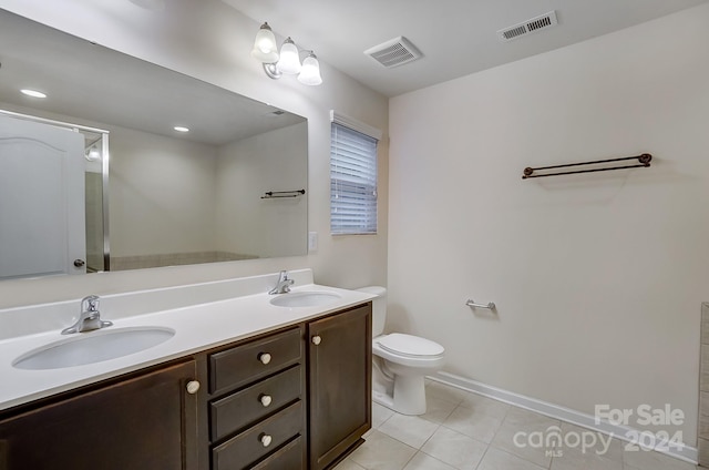 bathroom with tile patterned flooring, vanity, and toilet