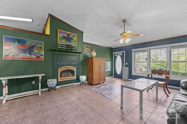 living room with a tiled fireplace, crown molding, tile patterned floors, lofted ceiling, and ceiling fan