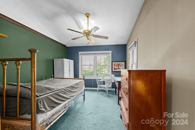 carpeted bedroom with lofted ceiling, ceiling fan, and ornamental molding