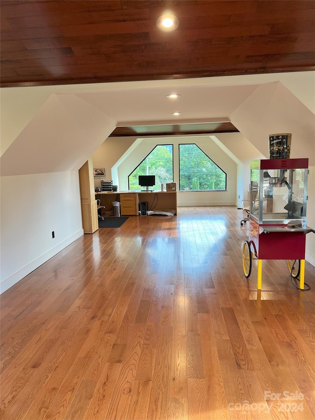 additional living space with lofted ceiling and hardwood / wood-style floors