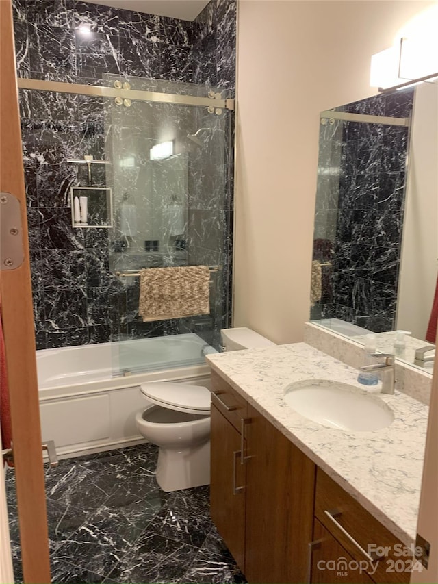 full bathroom featuring toilet, vanity, and enclosed tub / shower combo