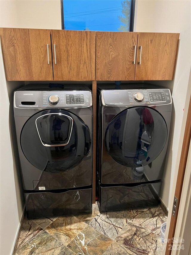 washroom featuring cabinets and independent washer and dryer