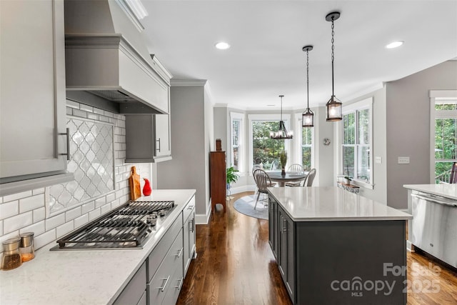 kitchen with tasteful backsplash, stainless steel appliances, pendant lighting, dark hardwood / wood-style floors, and a kitchen island