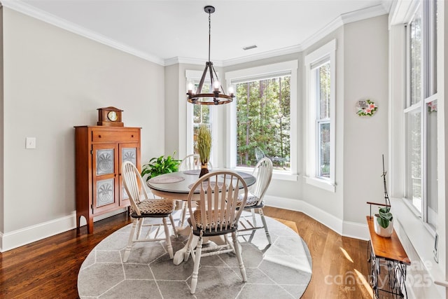 dining room featuring ornamental molding, dark hardwood / wood-style flooring, and a notable chandelier