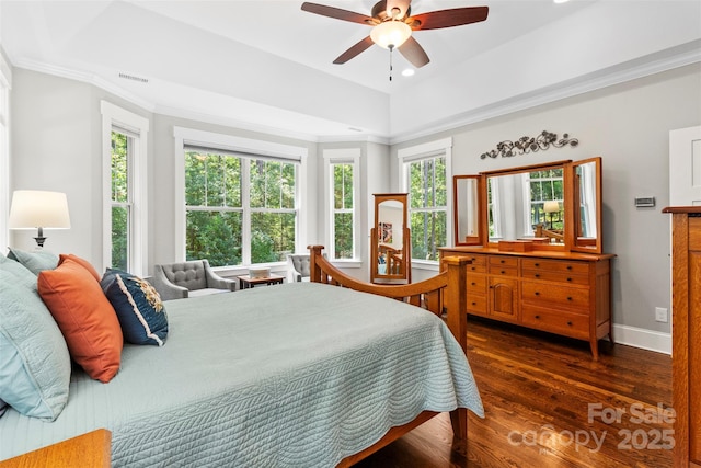 bedroom with ceiling fan, dark hardwood / wood-style flooring, ornamental molding, and a tray ceiling