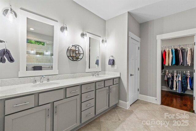 bathroom featuring tile patterned flooring, a shower, and vanity