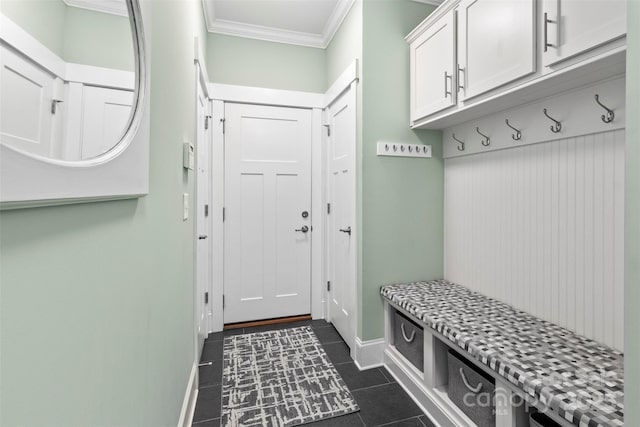 mudroom featuring dark tile patterned floors and ornamental molding