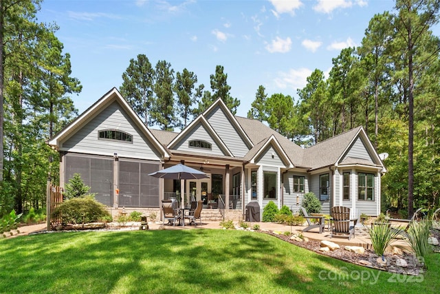 back of house with a yard, a patio area, and a sunroom