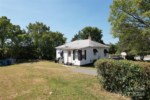 rear view of property featuring a yard