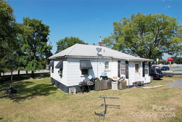 back of house with a lawn