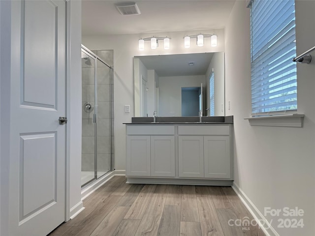 bathroom with vanity, hardwood / wood-style flooring, and walk in shower