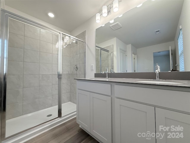 bathroom featuring hardwood / wood-style floors, vanity, and an enclosed shower