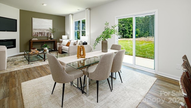 dining area with wood-type flooring and a healthy amount of sunlight