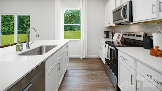 kitchen with white cabinetry, decorative backsplash, sink, stainless steel appliances, and dark hardwood / wood-style floors