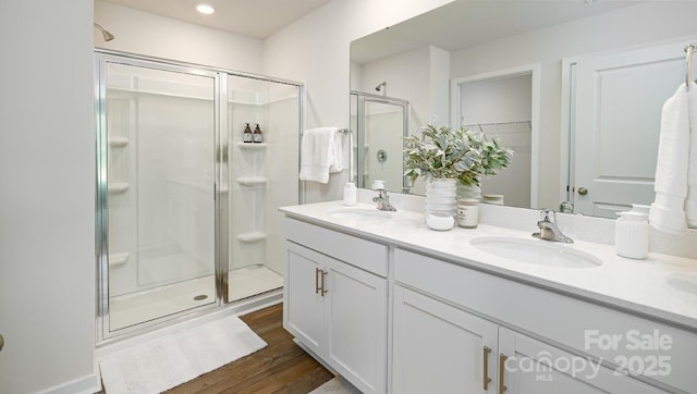 bathroom featuring vanity, hardwood / wood-style floors, and a shower with door