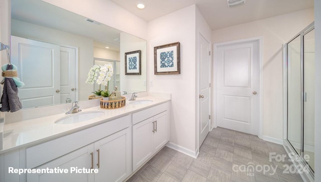 bathroom with a shower with door and vanity