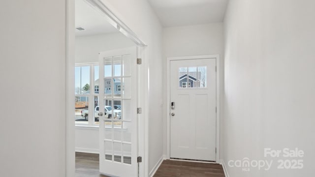 entrance foyer with dark wood finished floors, visible vents, and baseboards