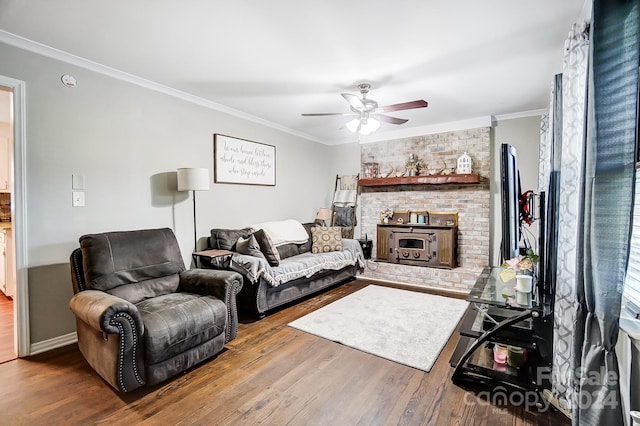 living room with ceiling fan, ornamental molding, wood-type flooring, and a fireplace