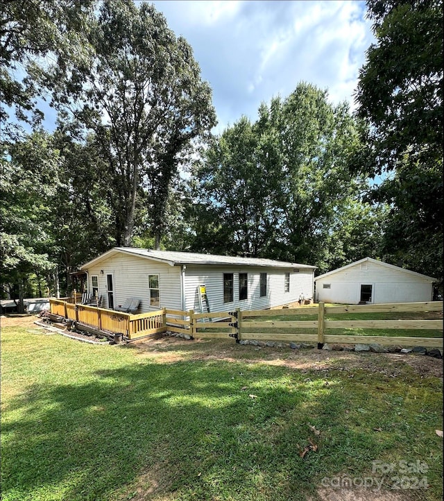 rear view of property featuring a yard and a deck