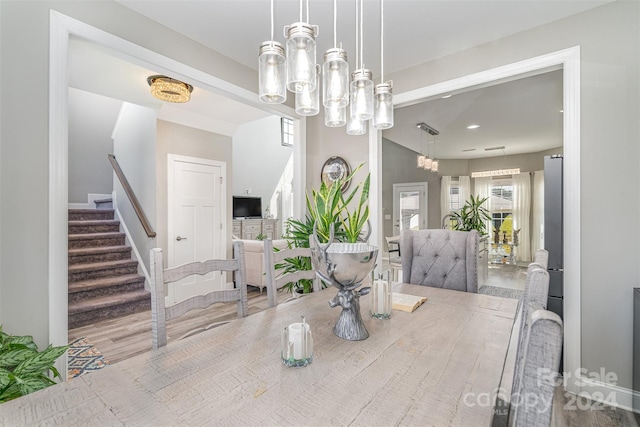 dining space featuring hardwood / wood-style flooring and a notable chandelier