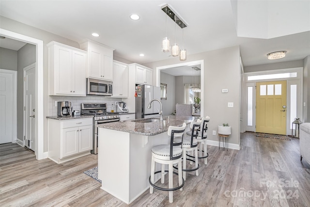 kitchen featuring stainless steel appliances, an inviting chandelier, sink, and white cabinets