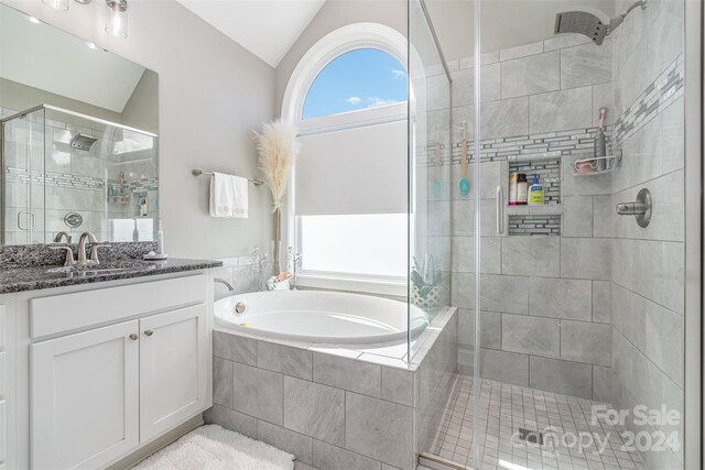 bathroom with vanity, lofted ceiling, and plus walk in shower