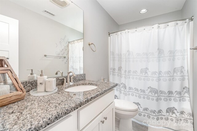 bathroom featuring vanity, toilet, and curtained shower