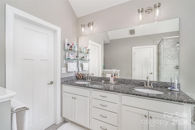 bathroom with vanity, vaulted ceiling, and walk in shower