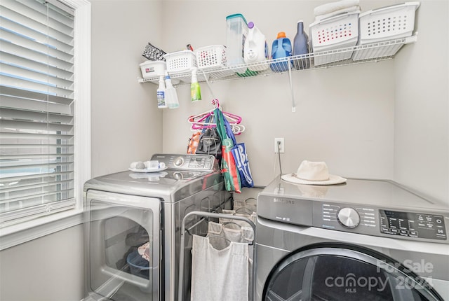 clothes washing area with a healthy amount of sunlight and washer and dryer