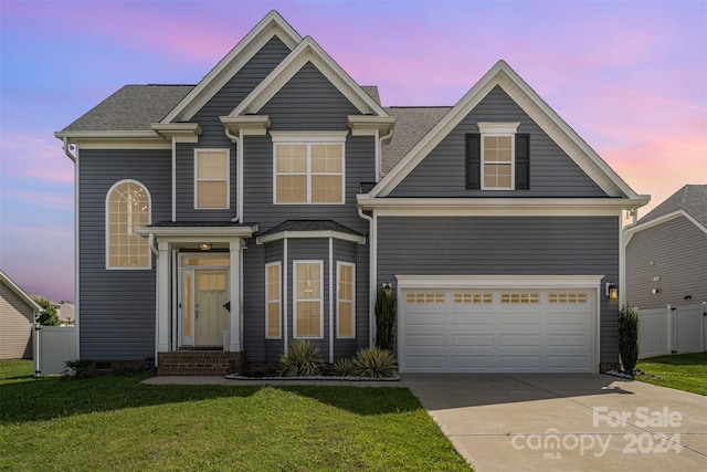 view of front of home featuring a lawn and a garage