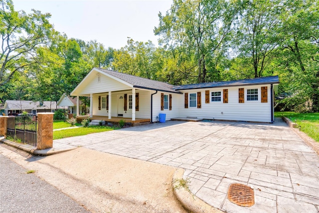 single story home featuring fence, a front yard, and a porch