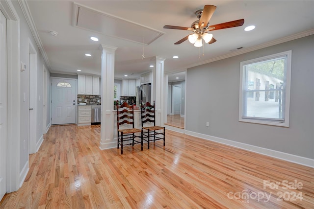 kitchen with crown molding, appliances with stainless steel finishes, light hardwood / wood-style floors, white cabinetry, and ceiling fan