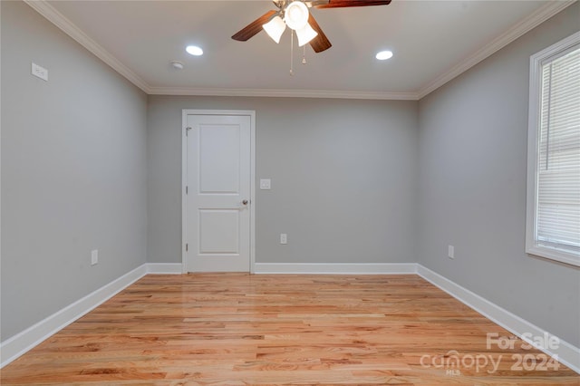 spare room featuring light wood-type flooring, ceiling fan, and crown molding