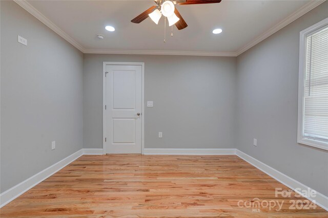 unfurnished room featuring crown molding, baseboards, light wood finished floors, a wealth of natural light, and a ceiling fan