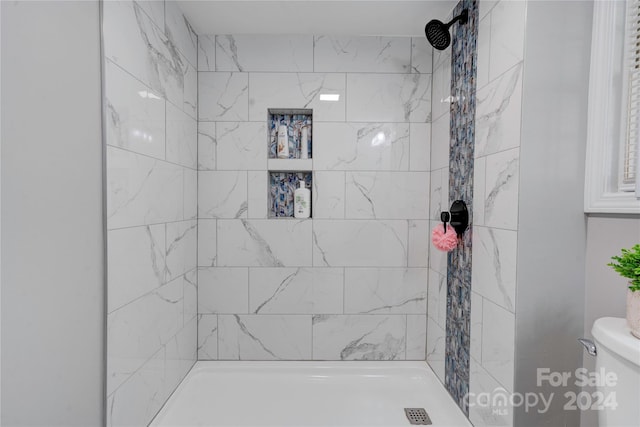 bathroom with toilet and tiled shower