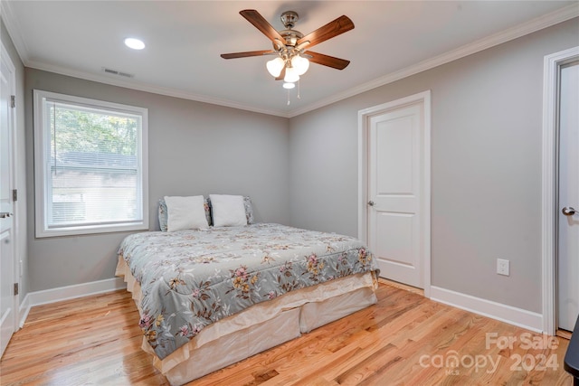 bedroom featuring crown molding, ceiling fan, and light wood-type flooring