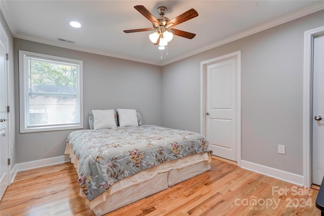 bedroom featuring crown molding, baseboards, light wood-style floors, visible vents, and a ceiling fan