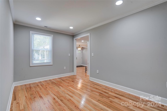 empty room featuring crown molding, recessed lighting, light wood-type flooring, baseboards, and visible vents
