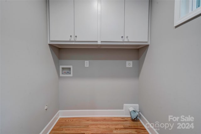 washroom with cabinet space, hookup for a washing machine, baseboards, and wood finished floors