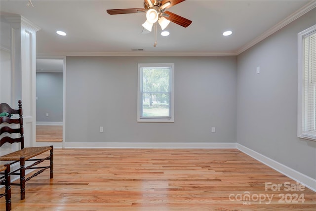 spare room featuring baseboards, light wood-style floors, ceiling fan, and ornamental molding