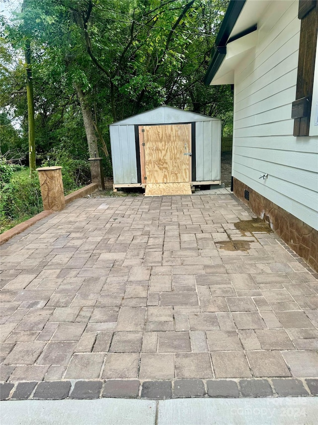 view of patio featuring an outdoor structure and a storage shed