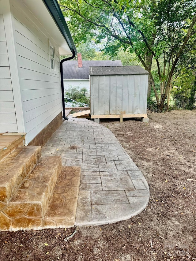 view of patio / terrace with an outbuilding and a shed
