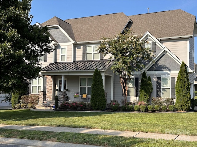 craftsman inspired home featuring covered porch and a front lawn