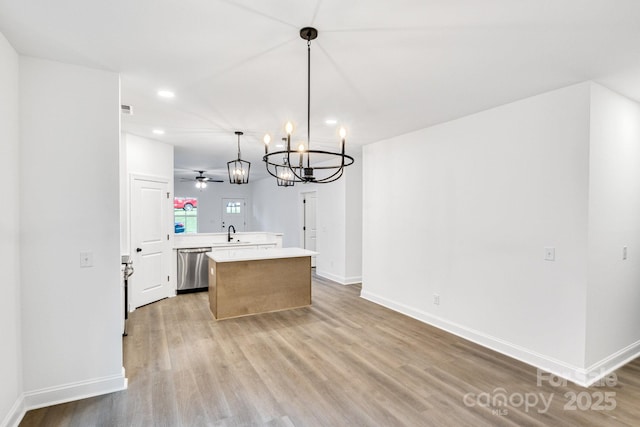 kitchen with ceiling fan with notable chandelier, sink, stainless steel dishwasher, decorative light fixtures, and kitchen peninsula