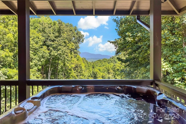 deck with a hot tub and a mountain view