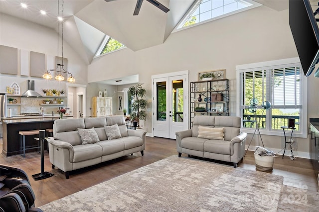 living room featuring an inviting chandelier, high vaulted ceiling, a healthy amount of sunlight, and dark hardwood / wood-style flooring