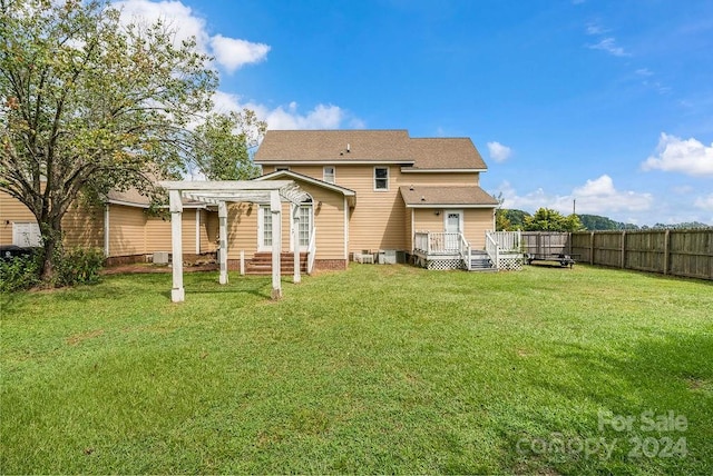 rear view of house featuring a pergola, a yard, and a deck